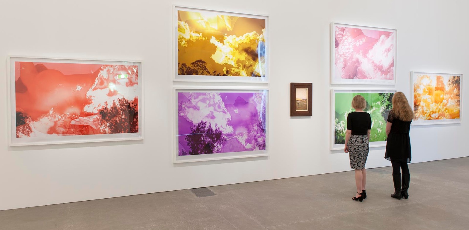QAGOMA exhibition, two women contemplate images of tree and sky with saturated colours.jpg