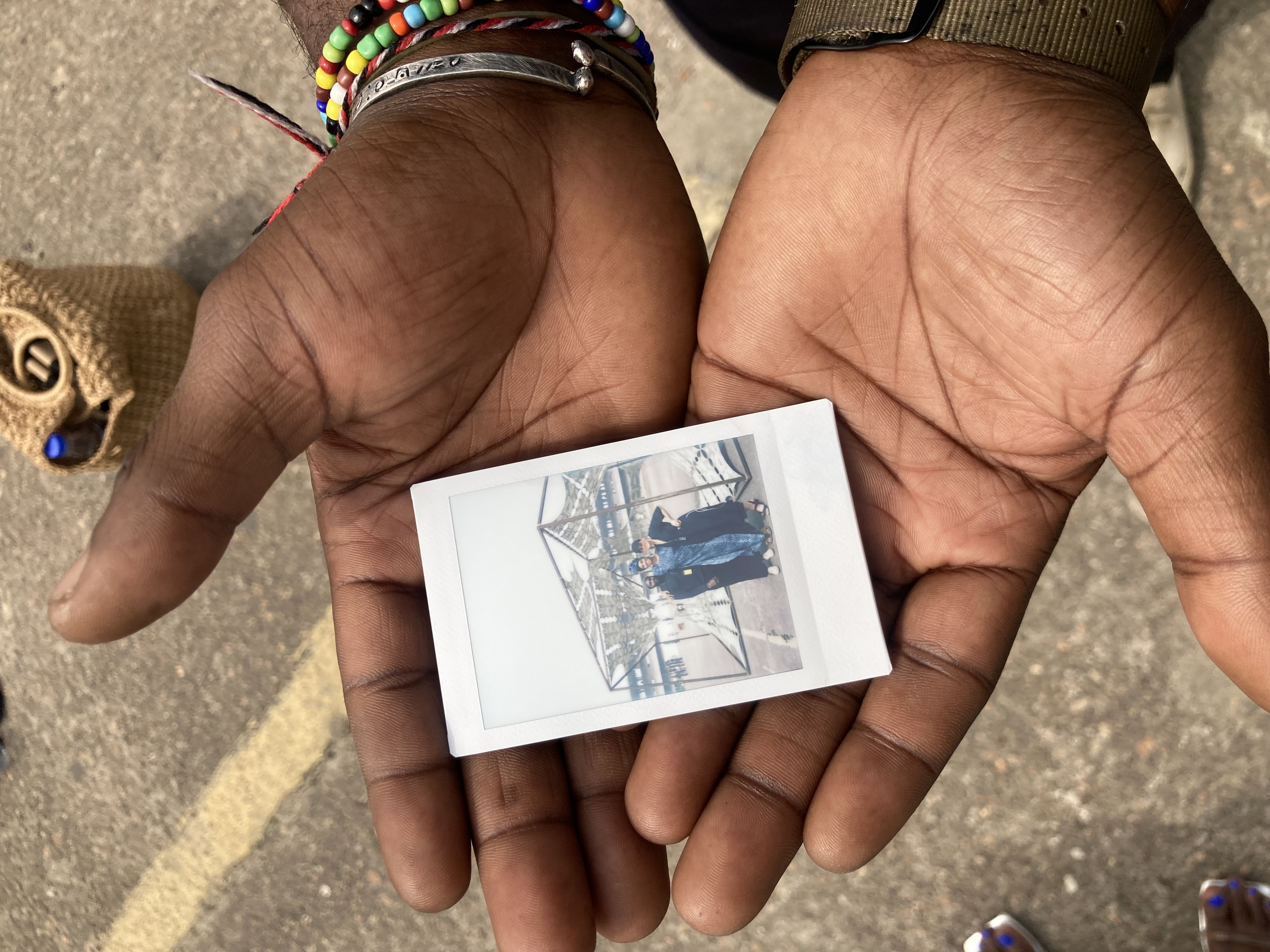 Individual holding polaroid image of Kathryn Weir and two artists in their hands.jpg